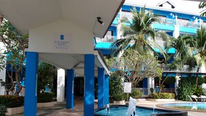 A resort with a covered entrance, a swimming pool, and palm trees. - Blue Garden Resort Pattaya (Pattaya)
