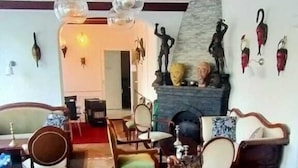 A spacious living room with wooden furniture, a fireplace, and decorative wall art.
