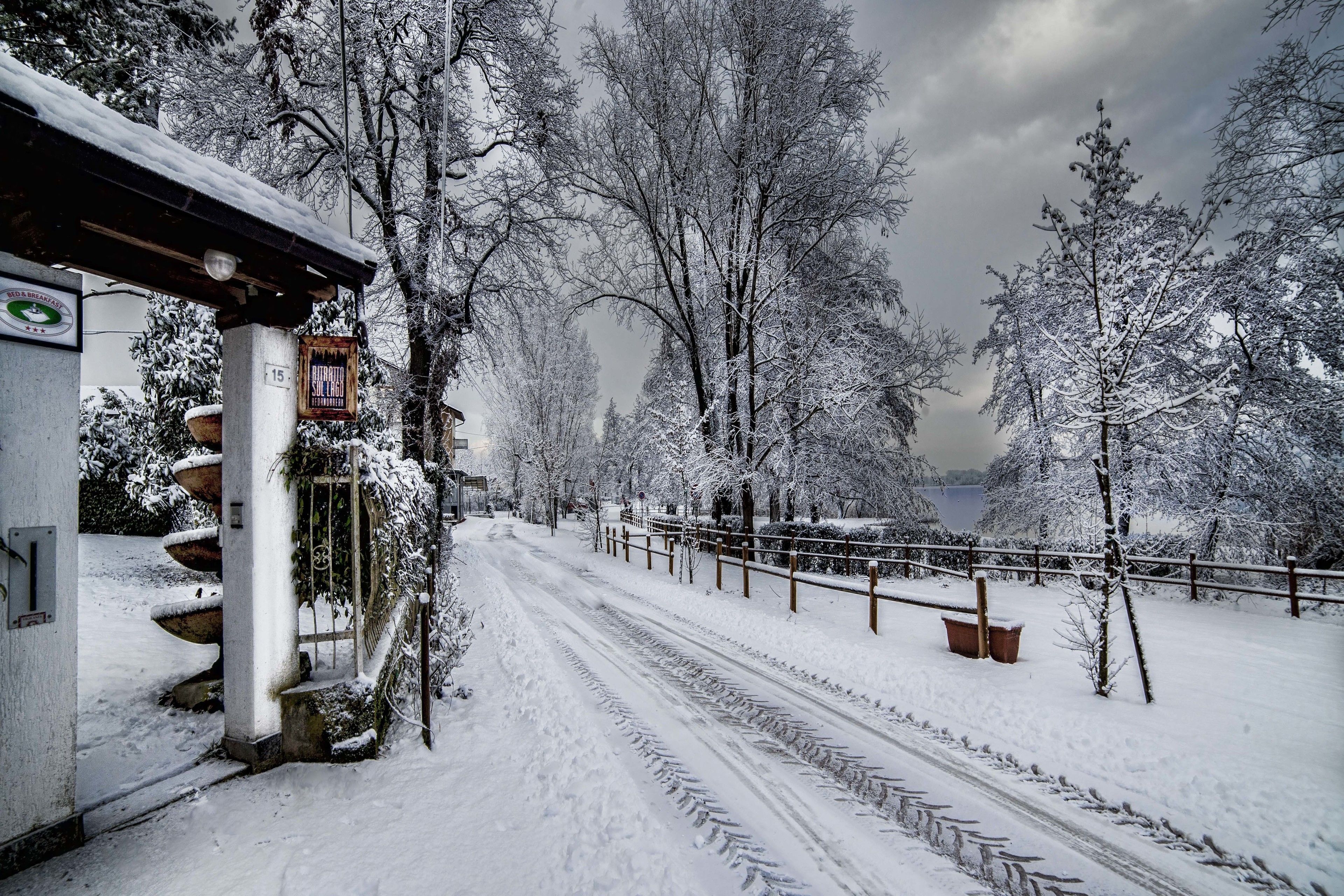 Un sentiero innevato che conduce a un edificio con una targa.