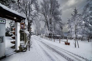 A snow-covered pathway leading to a building with a signboard. - Ritratto sul Lago (Dormelletto)