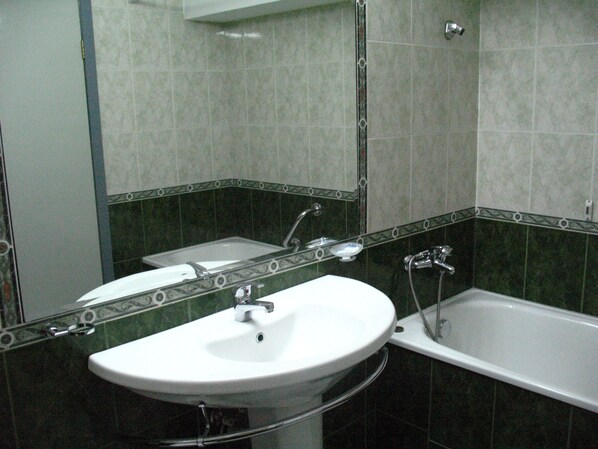 A bathroom with a white sink, a mirror, and a bathtub. - Chateau Hotel (Bansko)