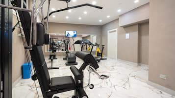 A gym with various exercise equipment, a TV screen, and a marble floor.