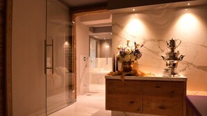 Une salle de bain moderne avec un meuble-lavabo en marbre, une cabine de douche en verre et un sol carrelé en marbre.