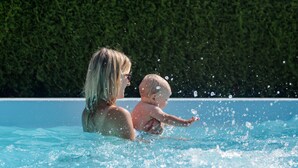 A person in a swimming pool with water splashing around. - Kärnten Apartment Turnersee (Sankt Kanzian am Klopeiner See)