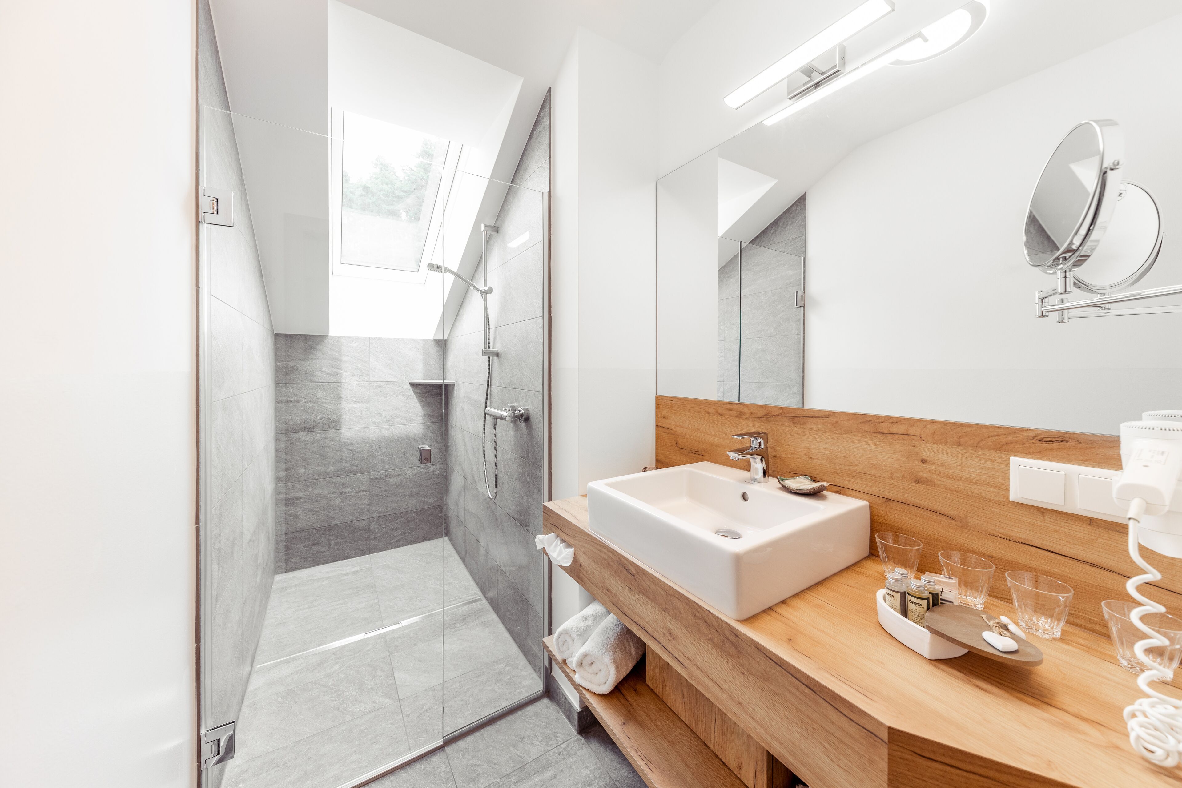 Un baño moderno con ducha, lavabo y tocador.