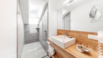 Un baño moderno con ducha, lavabo y tocador.