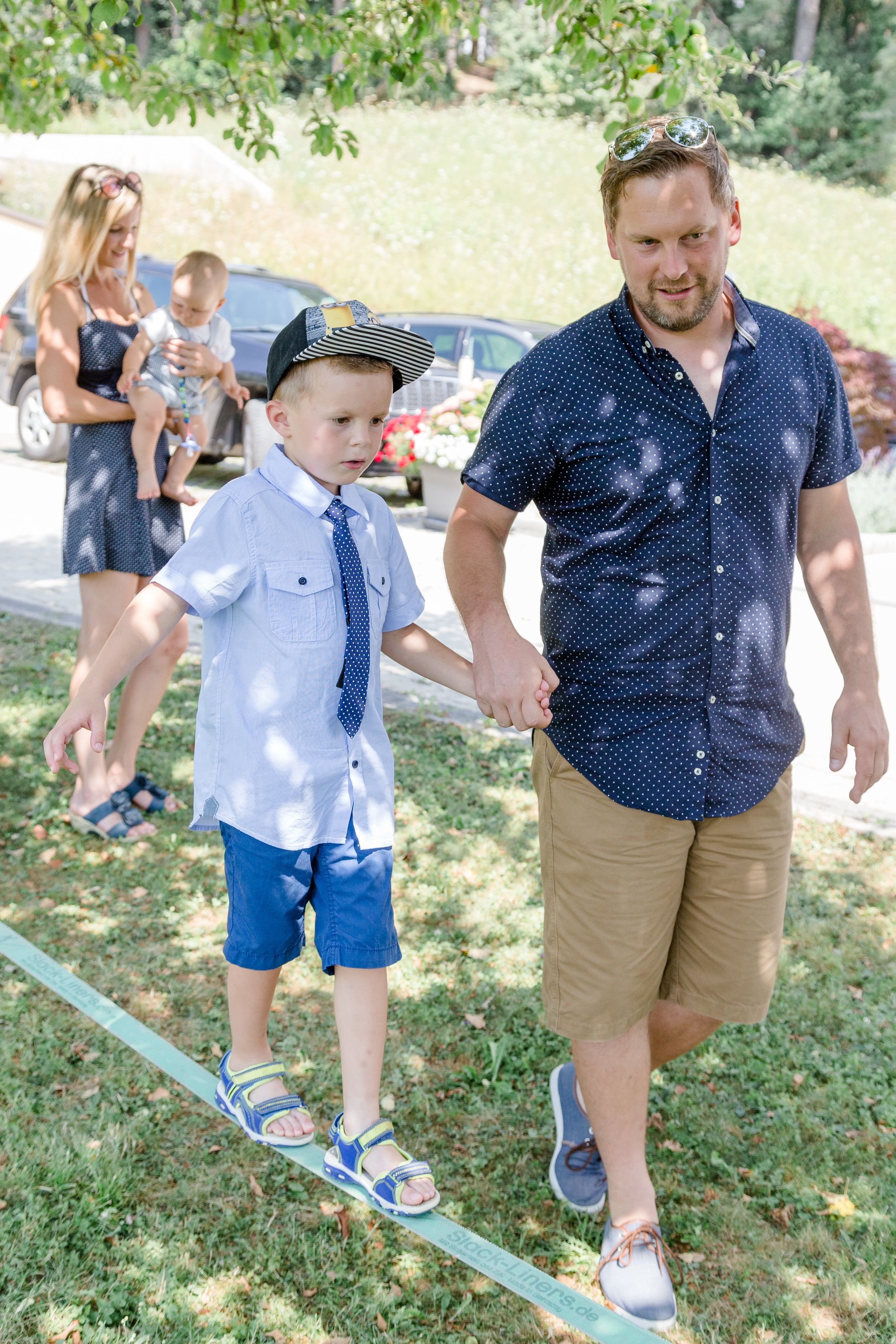 A man and a child walking on a rope bridge.
