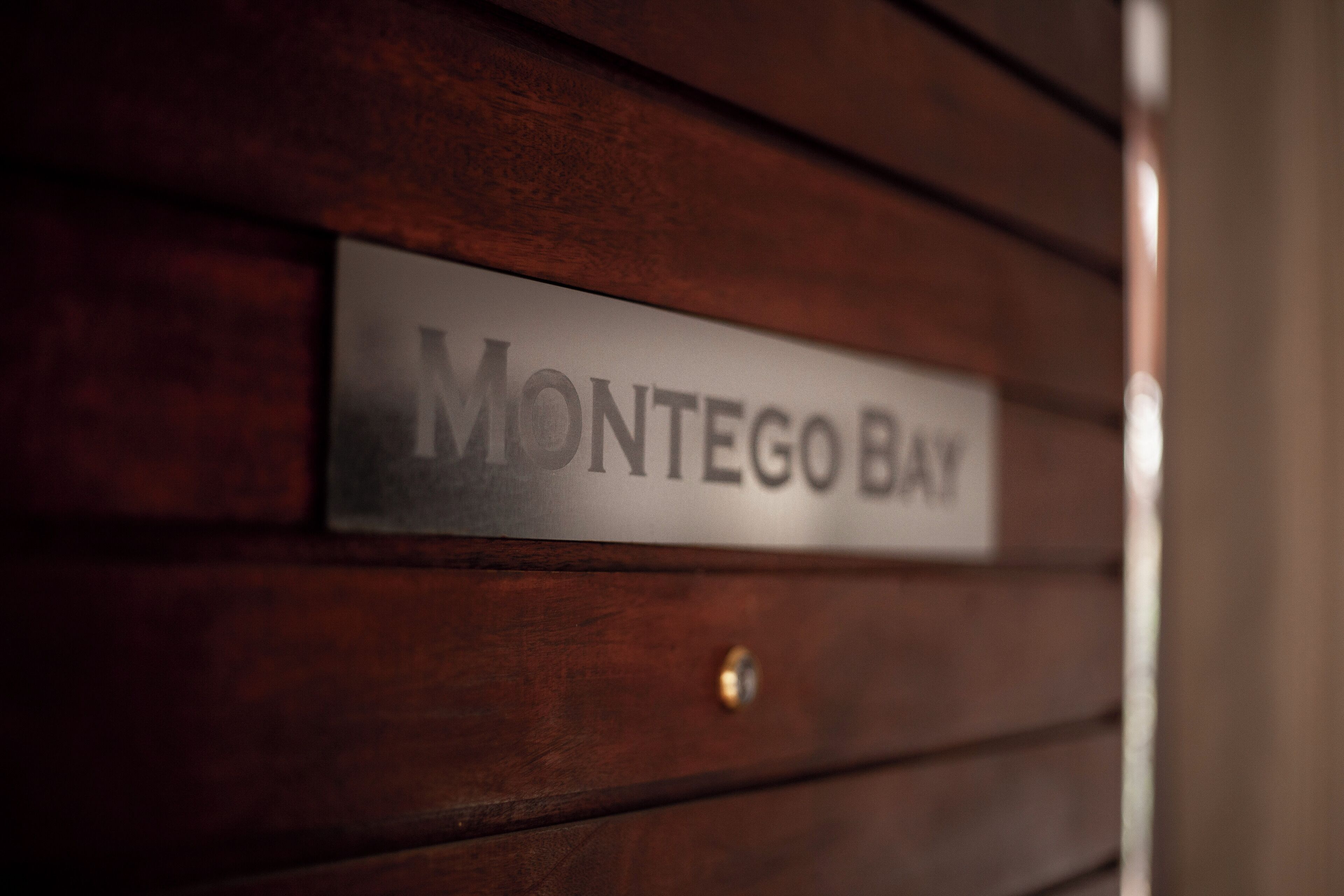 Un letrero con el texto 'Montego Bay' sobre una pared de madera.