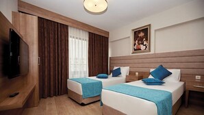 A hotel room with two beds, a TV, a painting, and a large window with curtains. - Bursa Suites Apart Hotel (Bursa)
