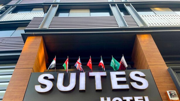 A hotel sign with the name "SUITES HOTEL" and multiple flags. - Bursa Suites Apart Hotel (Bursa)