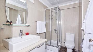 Une salle de bain moderne avec une douche à parois de verre, un lavabo blanc et des toilettes.