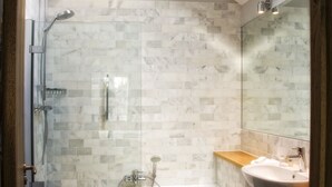 Een moderne badkamer met een douchecabine van glas, een vrijstaand bad en een wastafelmeubel.