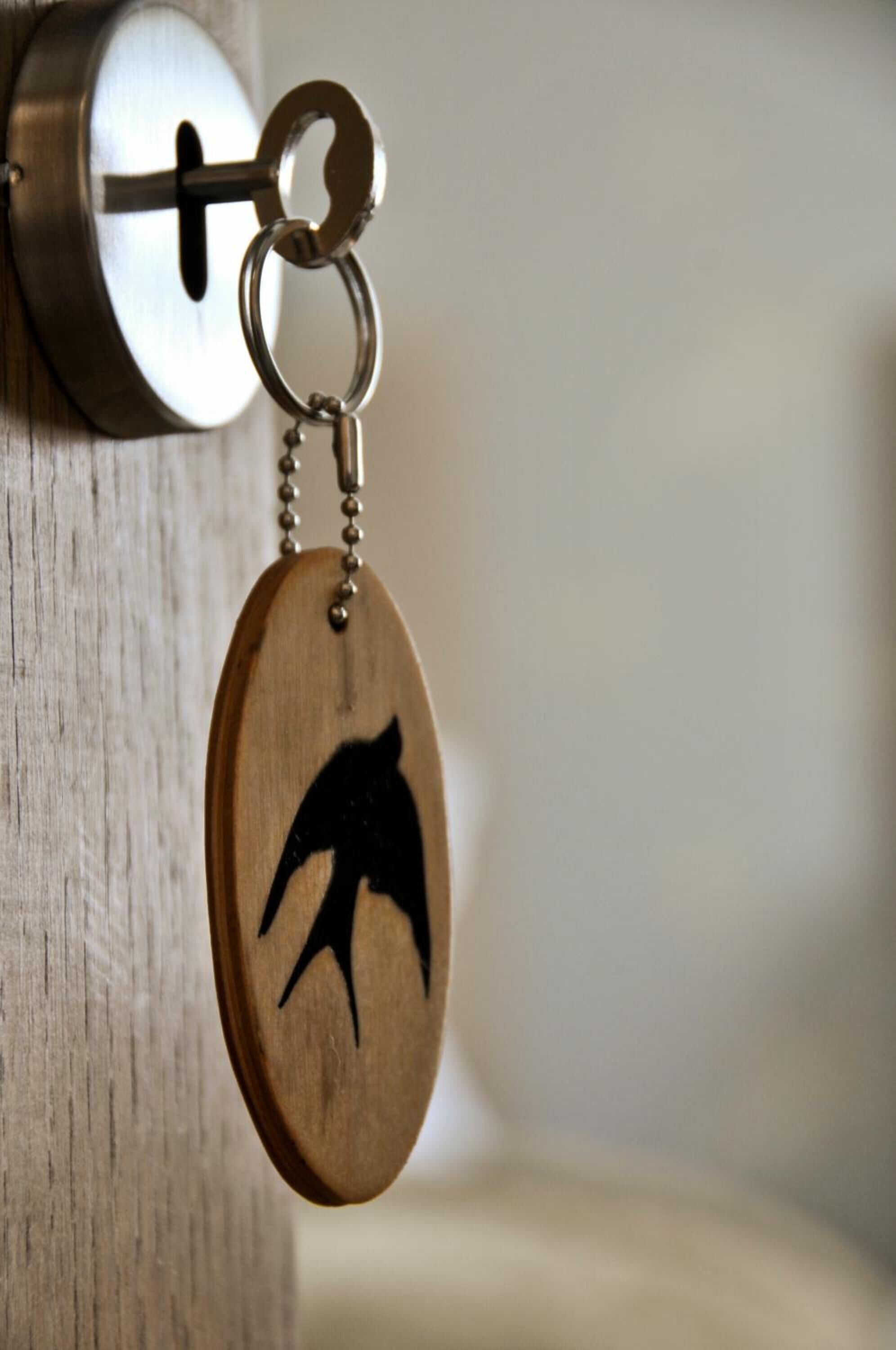 Un llavero con un atril de madera y una llave de metal insertada en una cerradura.