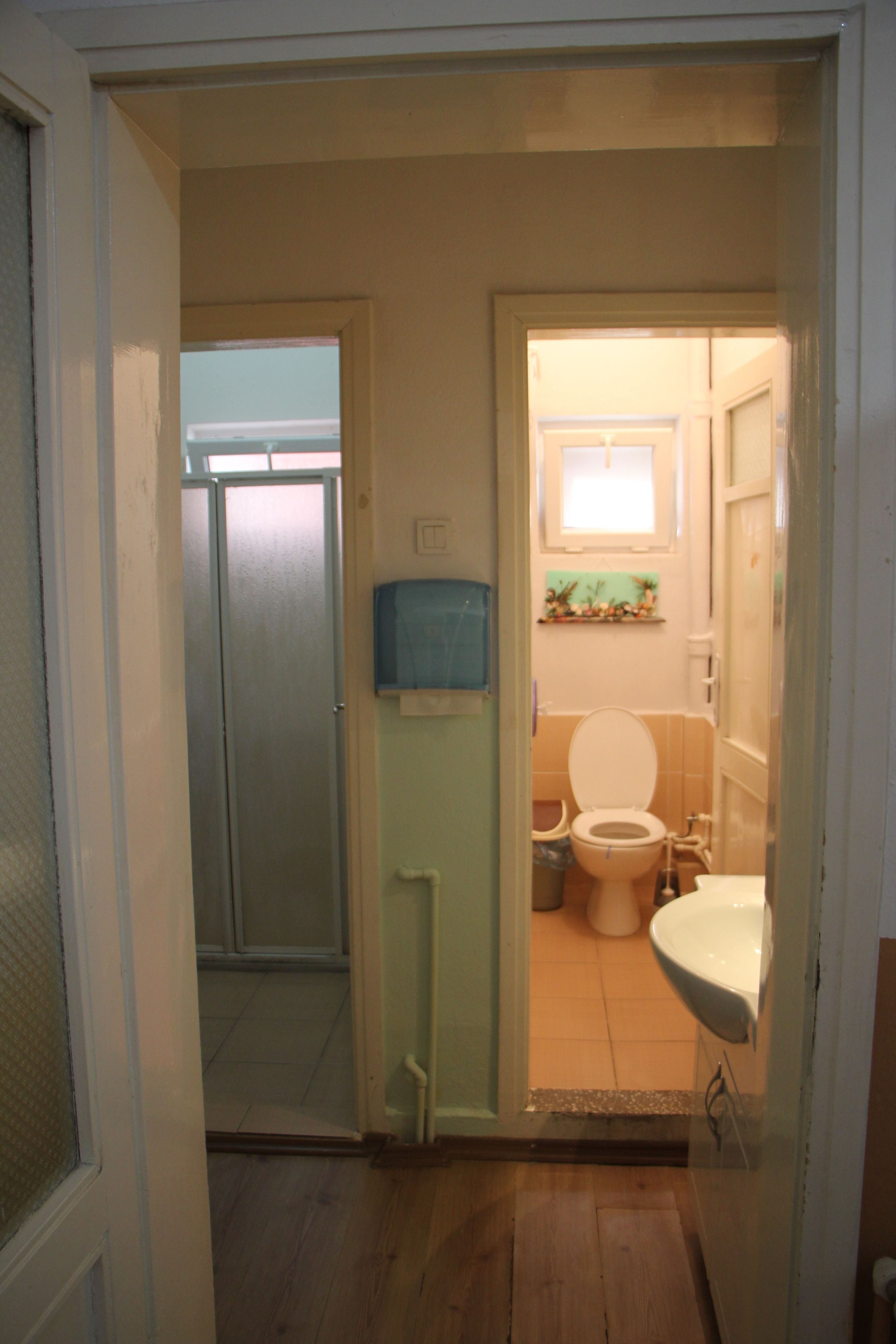A bathroom with a toilet, sink, and shower.