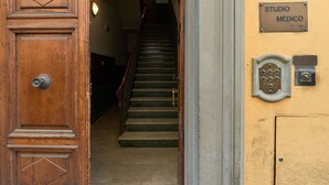 A wooden door with a brass handle, a staircase leading to a second floor, and a wall with signs for 'Residencia Martin Bed & Breakfast' and 'STUDIO MEDICO'. - Ariento House (Florence)
