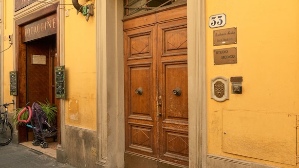 A yellow building with a wooden door and a sign that reads "BONDI FOCACCINE." - Ariento House (Florence)