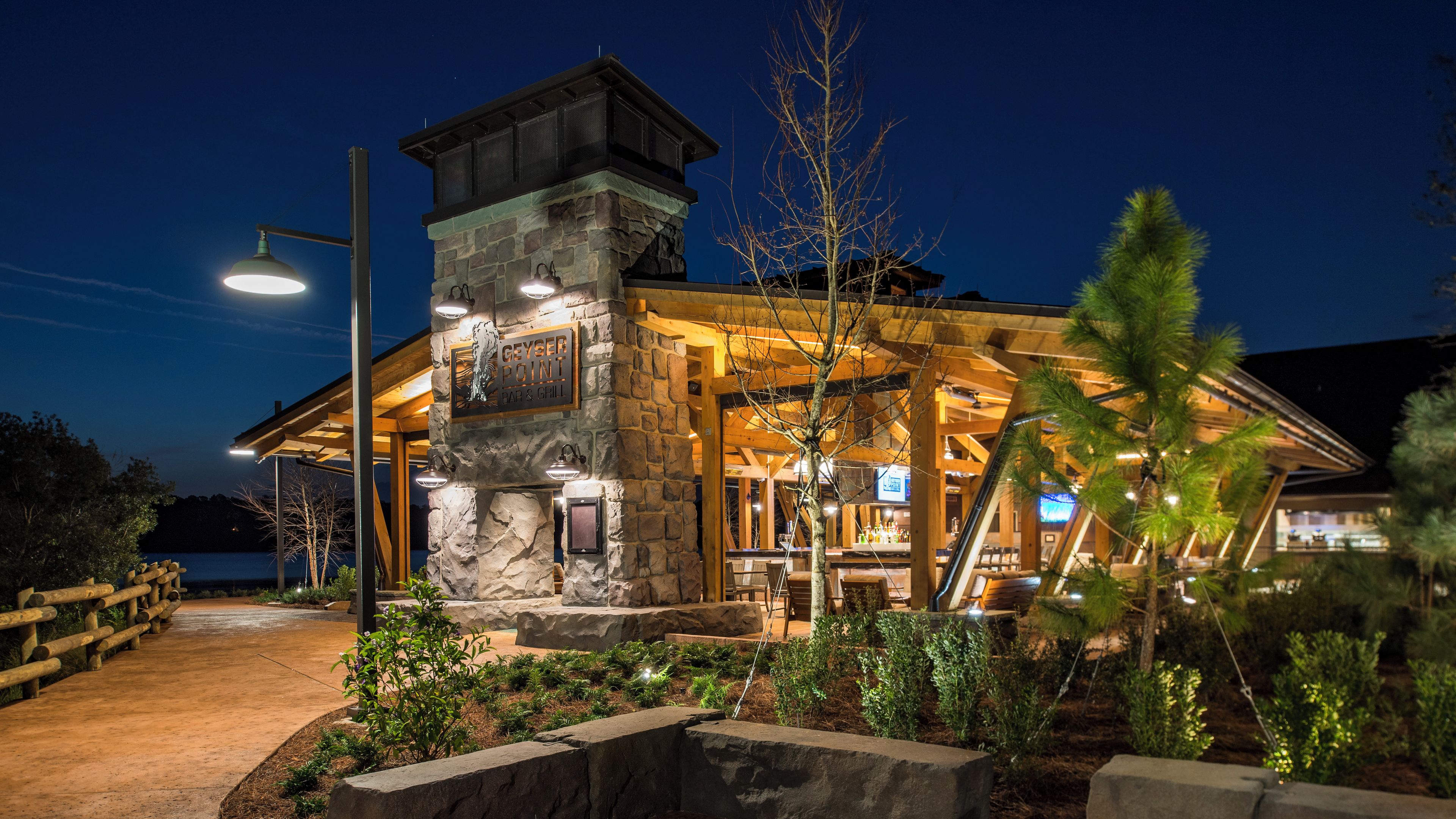 Un edificio de piedra con un letrero que dice 'Geyser Point Bar & Grill' durante la noche.