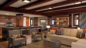 A modern living room with a sofa, armchairs, and a coffee table. There is a kitchen area with a microwave and stove. The room has wooden beams on the ceiling and a large window. - Copper Creek Villas & Cabins at Disney's Wilderness Lodge (Lake Buena Vista)