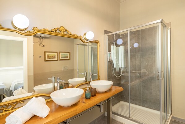 A bathroom with two sinks, a large mirror, and a glass-enclosed shower. - Residenza San Lorenzo (Florence)