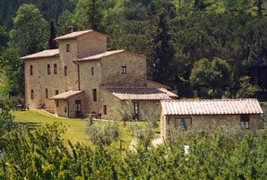 A stone building with multiple rooms, surrounded by lush greenery and trees.