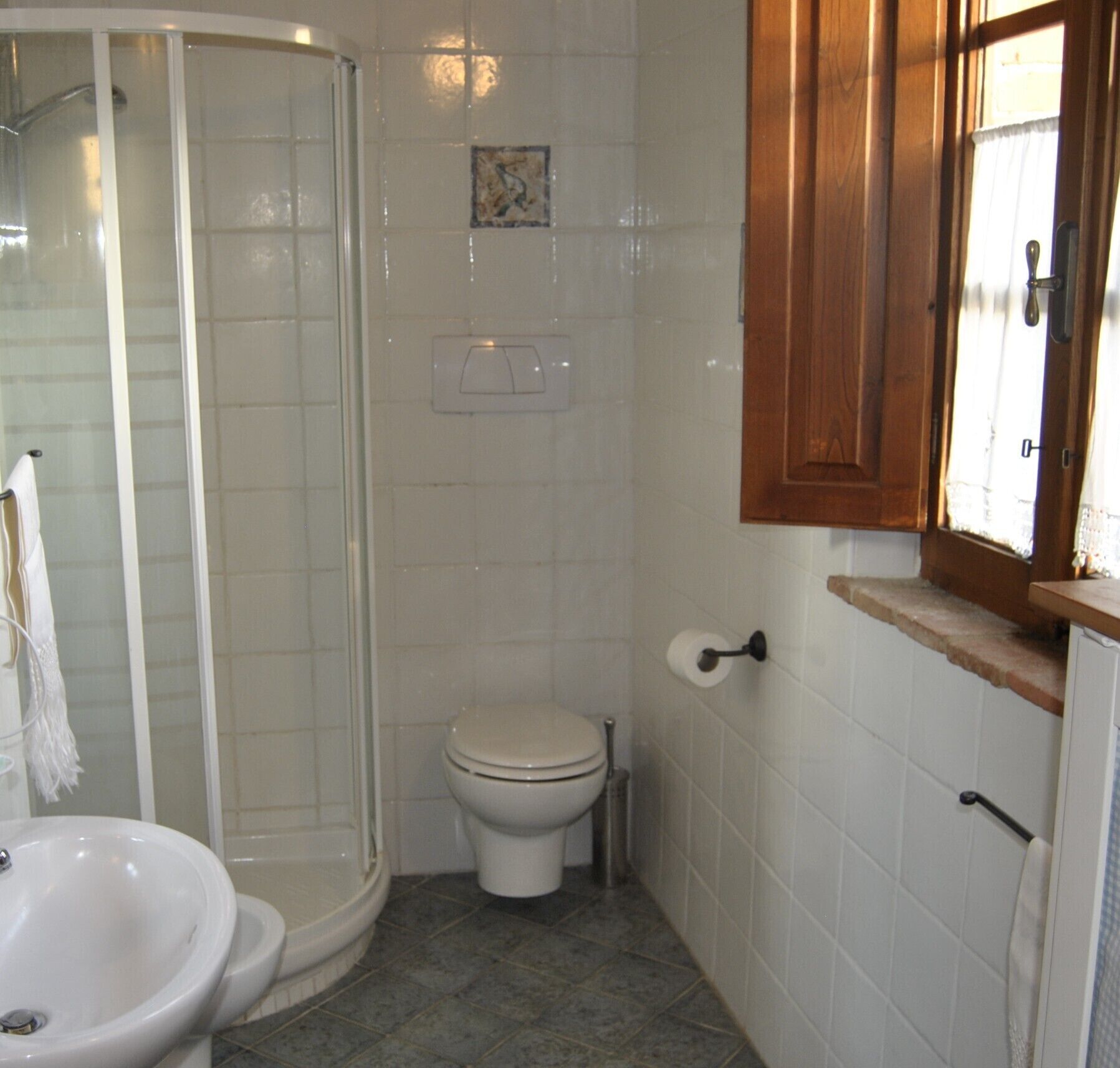 A bathroom with a shower, toilet, and sink.