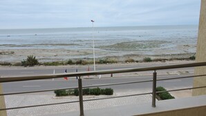 A view from a balcony overlooking a beach with a road in the foreground. - Hôtel Al Baraka (Fatou)