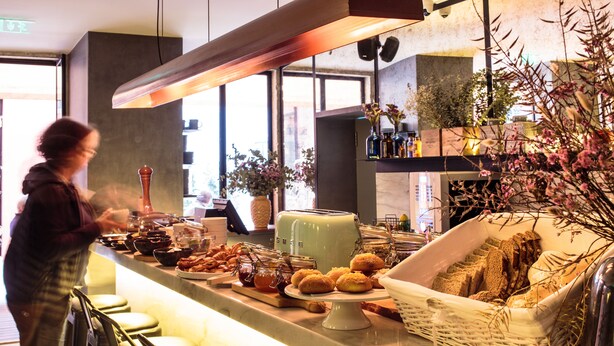 Ein Bereich mit Buffet, verschiedenen Speisen, einem Toaster und einem Brötchenkorb.