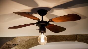 A ceiling fan with wooden blades and a light bulb hanging from it.