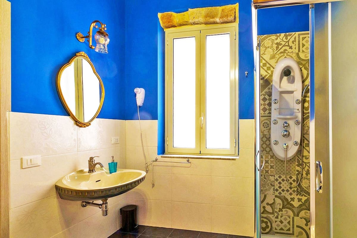 Une salle de bain avec un lavabo, un miroir et une douche.