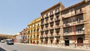 A multi-story building with a classic architectural style, featuring balconies and arched windows. - Hollywood Inn Palermo Rooms (Palermo)