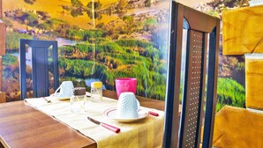 A dining table with a placemat, a white ceramic cup, a pink bowl, a glass jar, and a knife. - Hollywood Inn Palermo Rooms (Palermo)