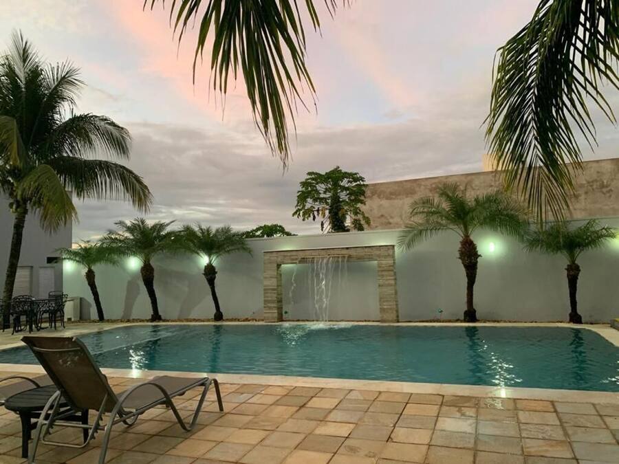 Una piscina al aire libre, sillones reclinables de piscina