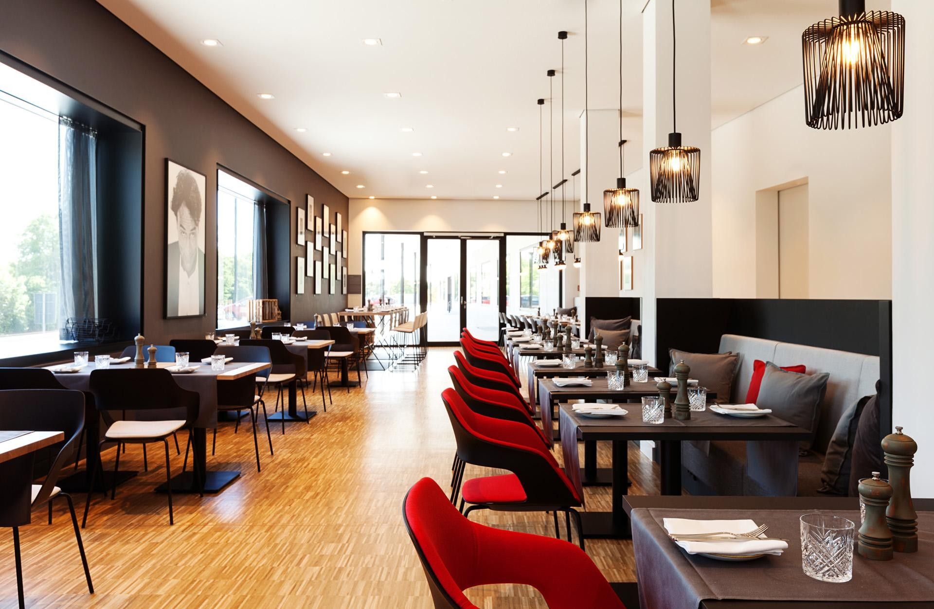 Un restaurante moderno con un amplio salón comedor, varias mesas y sillas.