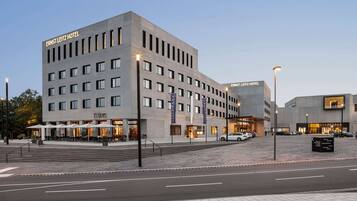 Experience the sleek, modern architecture of the Ernst Leitz Hotel, featuring ample windows and outdoor seating areas.