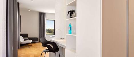 A modern room with a desk, chair, and a view of the outdoors.