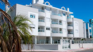 A modern multi-story building with balconies, a gated entrance, and a clear blue sky. - Praia dos Ingleses Belo Recanto da Ilha (Florianópolis)