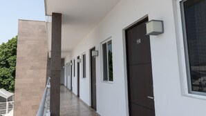 A modern building with a long corridor, doors numbered 112, and a balcony with a railing. - Nova Hotel (Cadereyta Jimenez)