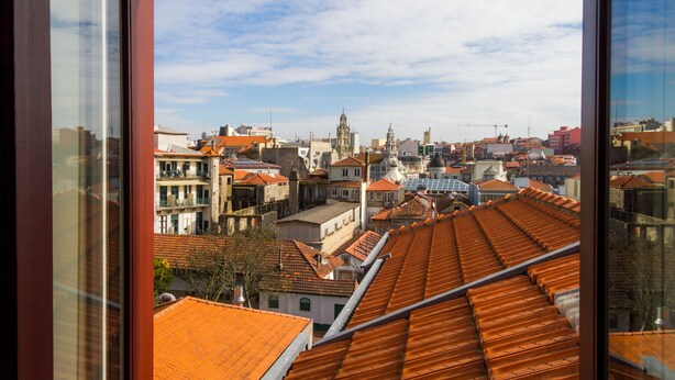 A cityscape with red-tiled roofs and a prominent church tower. - Liiiving in Porto - Historic Clerigos Studio 4F (Porto)
