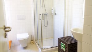 A bathroom with a toilet, a glass-enclosed shower, and a sink. - Liiiving in Porto - Historic Clerigos Studio 4F (Porto)