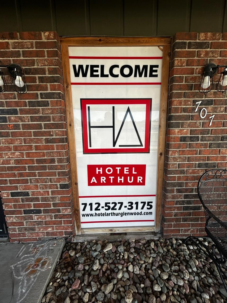 A welcome sign for Hotel Arthur with a contact number and website.