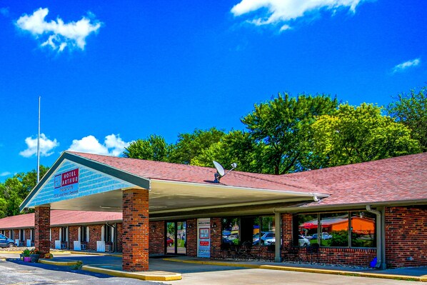 A two-story brick building with a covered parking area and a sign reading "Hotel Arthur." - Hotel Arthur (Glenwood)