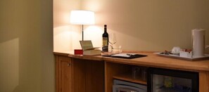 A wooden desk with a lamp, a bottle of wine, a glass, and a cup. - B&B Oberdan18 (Verona)