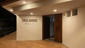 Exterior do Hotel CASA CHENTE com um deck de madeira e uma placa sobre a entrada.