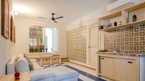 A modern living room with a sofa, a small table, and a ceiling fan. - Casa Luca (Playa del Carmen)