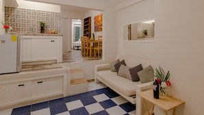 A compact living space with a kitchenette, dining area, and a sofa with a side table. - Casa Luca (Playa del Carmen)