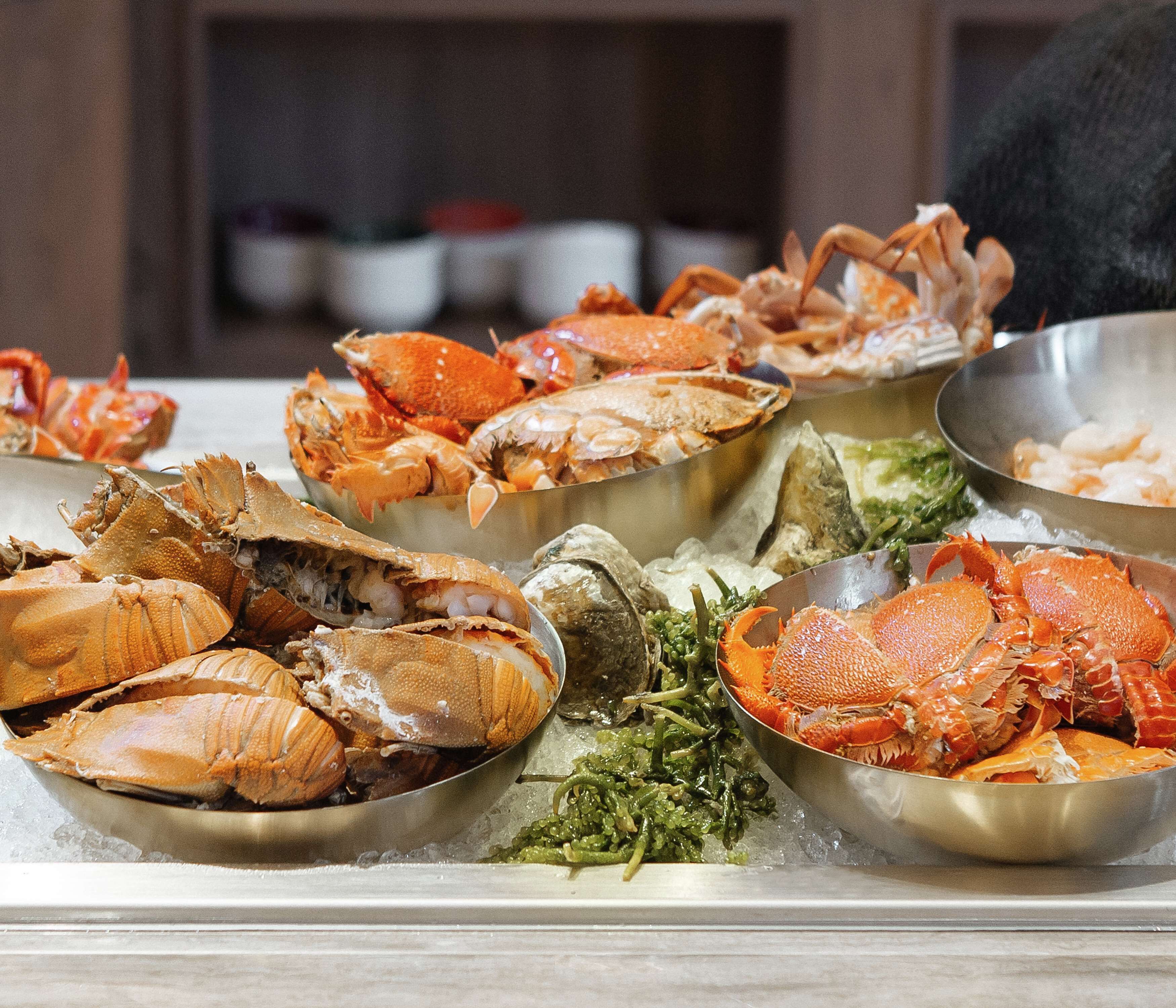 A seafood display with various types of crabs and oysters on ice.