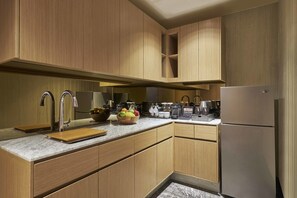 A modern kitchen with wooden cabinets, stainless steel appliances, and a marble countertop. - Hilton Manila Newport World Resorts (Pasay)