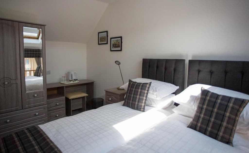Un dormitorio con cama, cómoda, escritorio y espejo.