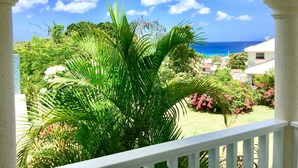 A balcony with a view of the ocean and lush greenery. - La Porta Della Casa (Prospect)