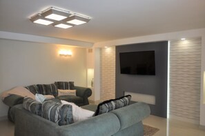 Departamento Premium, 1 habitación, vista parcial al mar, frente al mar | Sala de estar | Televisión de pantalla plana de 55 pulgadas con canales por cable 